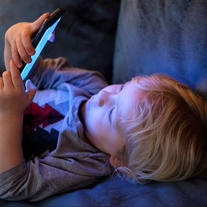 Un enfant regardant un smartphone.